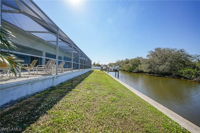 view of yard with a water view and glass enclosure