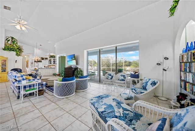 living room featuring ceiling fan with notable chandelier, high vaulted ceiling, and light tile patterned flooring