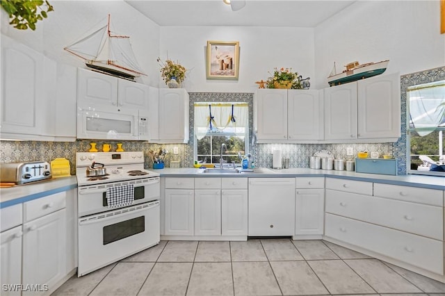 kitchen featuring white appliances, decorative backsplash, and white cabinets