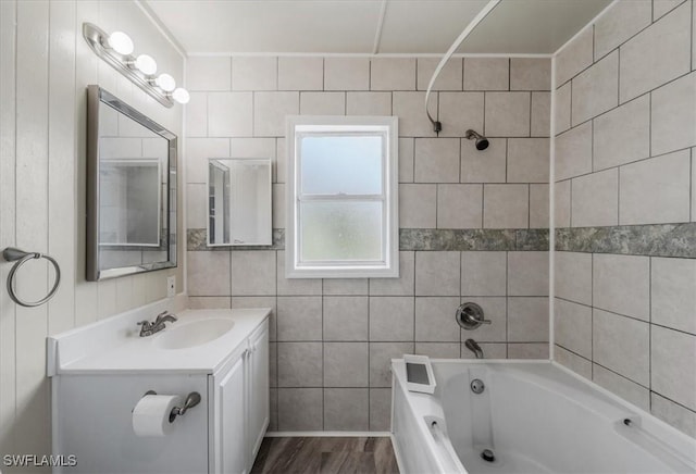 bathroom featuring washtub / shower combination, vanity, and wood-type flooring