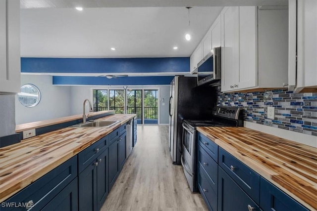 kitchen with stainless steel appliances, sink, white cabinets, and wood counters