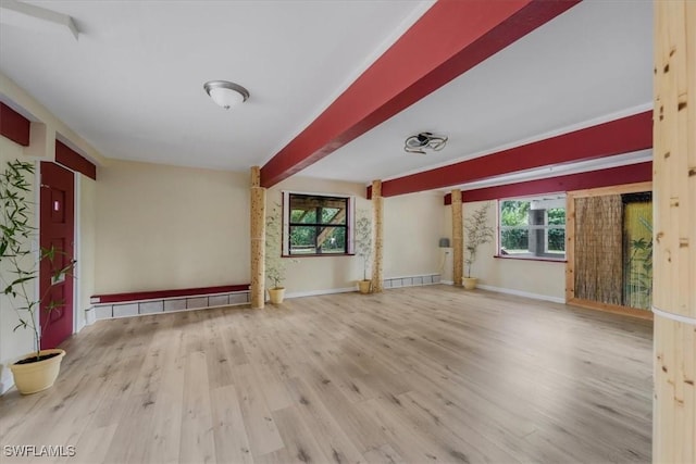 unfurnished living room featuring beam ceiling and light hardwood / wood-style flooring