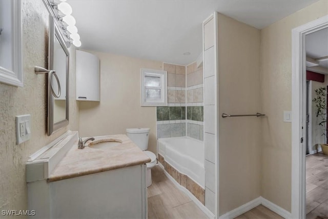 bathroom with vanity, toilet, hardwood / wood-style floors, and a bath