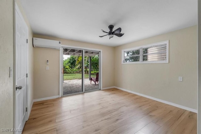 unfurnished room with a wall mounted AC, ceiling fan, and light hardwood / wood-style flooring