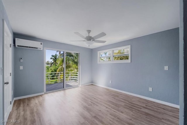 unfurnished room featuring ceiling fan, a wall mounted AC, and light hardwood / wood-style floors