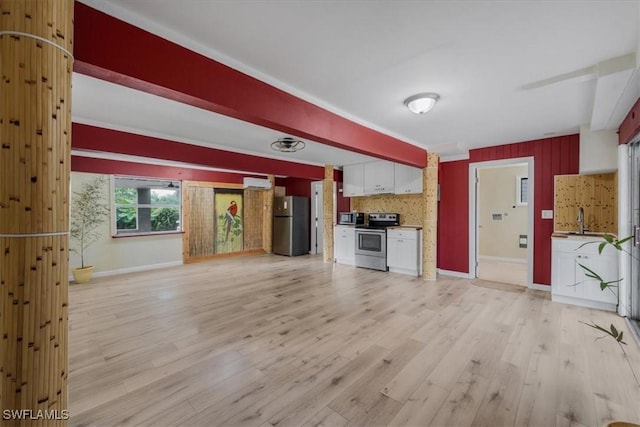 kitchen with white cabinetry, a wall unit AC, stainless steel appliances, light hardwood / wood-style floors, and beamed ceiling