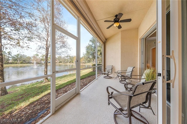 sunroom / solarium with a water view, ceiling fan, and vaulted ceiling