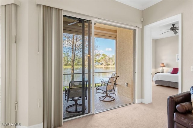 doorway to outside featuring a water view, ceiling fan, and carpet