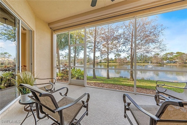 sunroom / solarium featuring a water view and ceiling fan