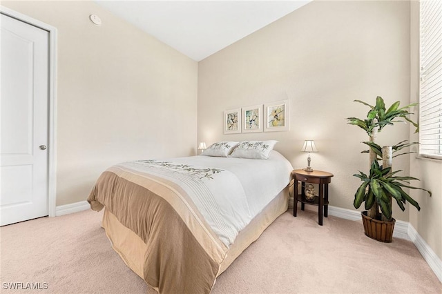 carpeted bedroom with lofted ceiling