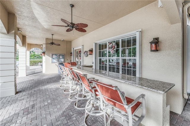 view of patio / terrace featuring an outdoor bar and ceiling fan