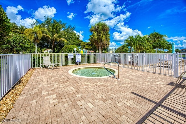 view of swimming pool featuring a hot tub and a patio