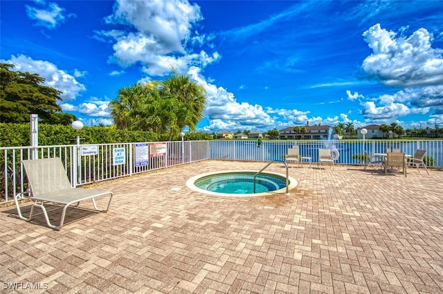 view of swimming pool with a community hot tub, a patio, and a water view