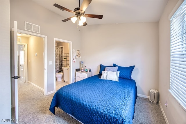 carpeted bedroom with ceiling fan and ensuite bath