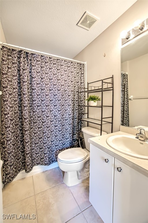 bathroom with tile patterned flooring, vanity, and toilet