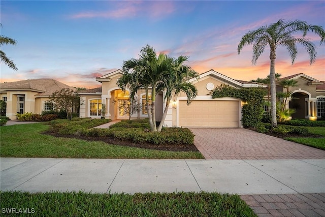 mediterranean / spanish-style home featuring a yard and a garage