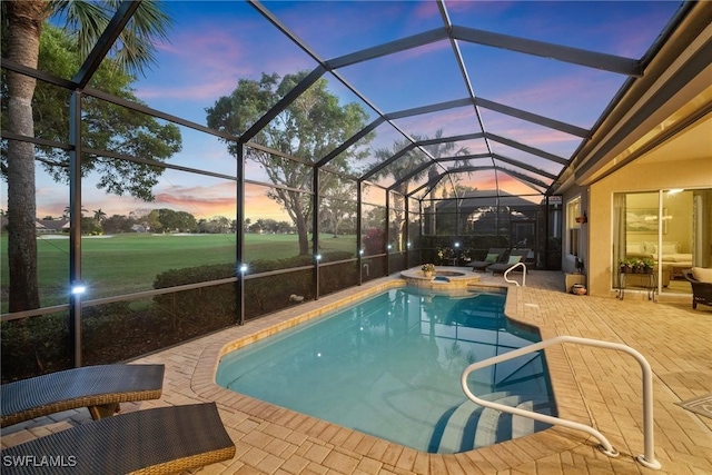 pool at dusk with an in ground hot tub, glass enclosure, and a patio area