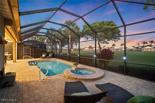 pool at dusk with a lanai and a patio area