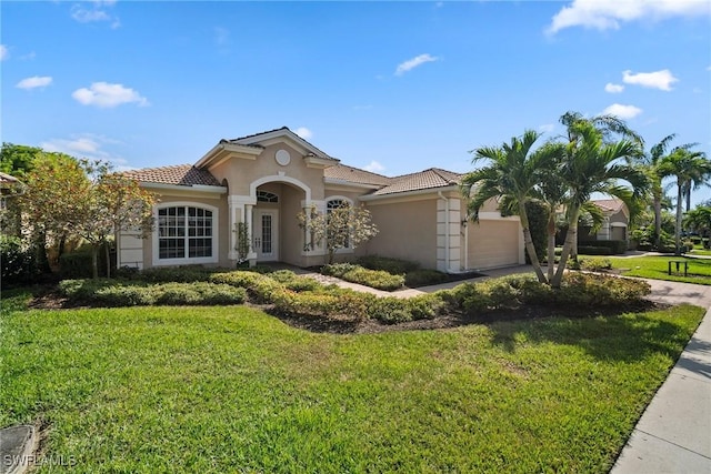 mediterranean / spanish-style house featuring a garage and a front lawn