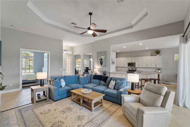 tiled living room featuring crown molding, a tray ceiling, and ceiling fan