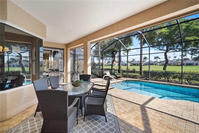 view of swimming pool with area for grilling, a patio, and glass enclosure