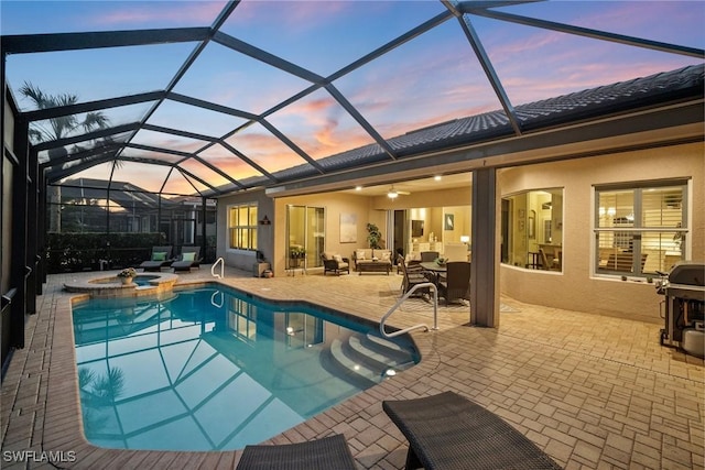 pool at dusk with ceiling fan, outdoor lounge area, a patio, glass enclosure, and area for grilling