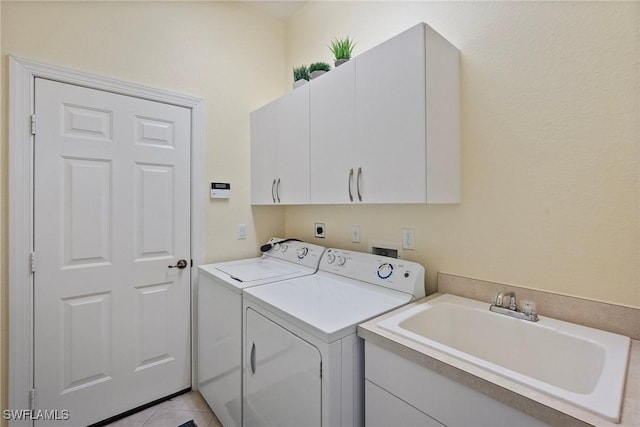 laundry room featuring sink, washer and clothes dryer, cabinets, and light tile patterned flooring