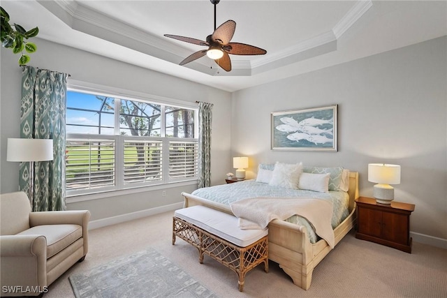 bedroom with crown molding, a tray ceiling, light carpet, and ceiling fan