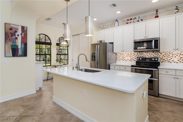 kitchen featuring appliances with stainless steel finishes, white cabinets, a kitchen island with sink, and hanging light fixtures