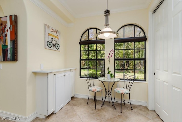 dining space with light tile patterned floors, ornamental molding, and baseboards