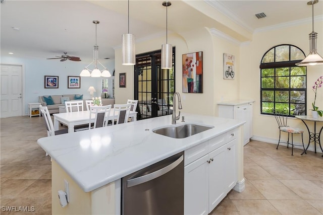 kitchen with decorative light fixtures, stainless steel dishwasher, a kitchen island with sink, white cabinets, and a sink