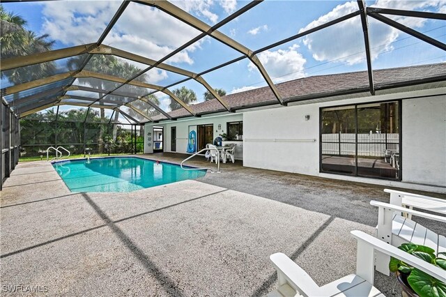 view of swimming pool featuring a patio area and glass enclosure