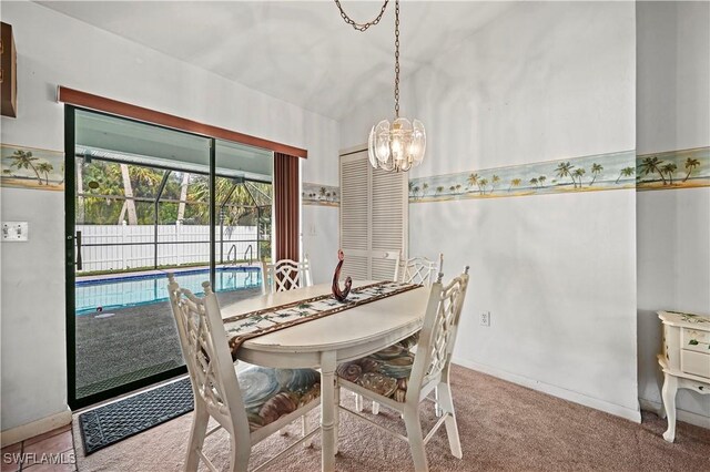 carpeted dining area with vaulted ceiling and a notable chandelier