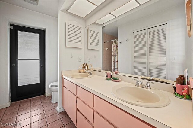 bathroom with tile patterned flooring, vanity, and toilet