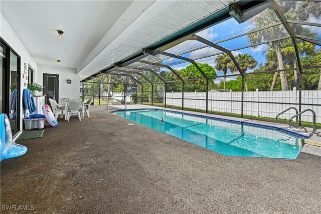 view of swimming pool featuring a patio and glass enclosure