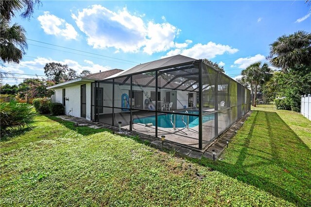 view of pool featuring a patio area, glass enclosure, and a lawn