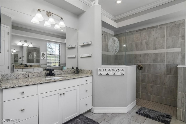 bathroom featuring crown molding, tiled shower, and vanity