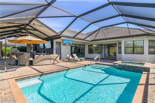 view of pool with an in ground hot tub, exterior bar, glass enclosure, and a patio