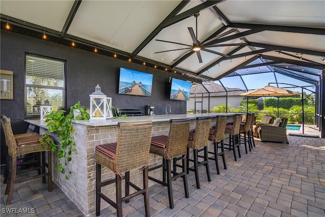 view of patio featuring a lanai and an outdoor bar