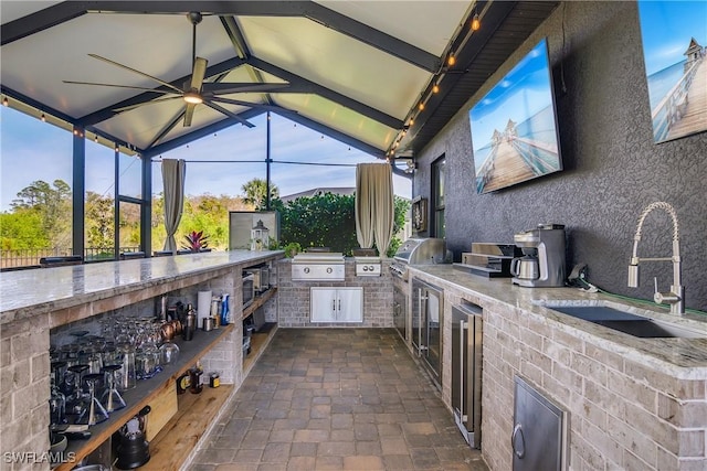 view of patio featuring sink, a lanai, a grill, and exterior kitchen