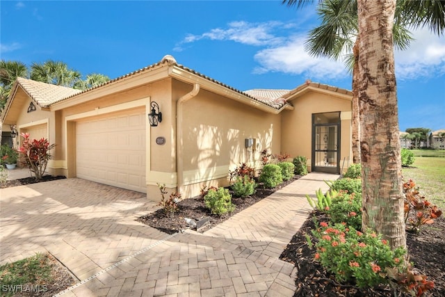 20017 Serre Dr, Estero, FL 33928 - view of front of home featuring a garage, stucco siding, a tiled roof, and decorative driveway