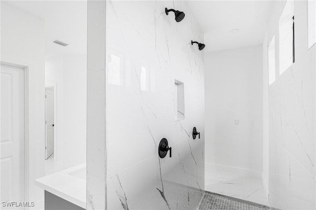 bathroom featuring a tile shower and vanity