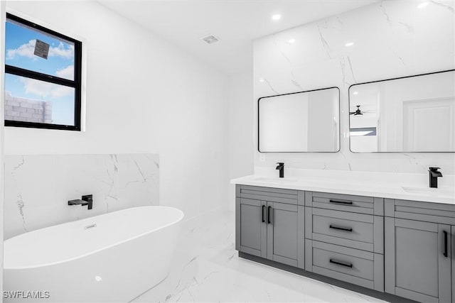 bathroom featuring a tub to relax in and vanity