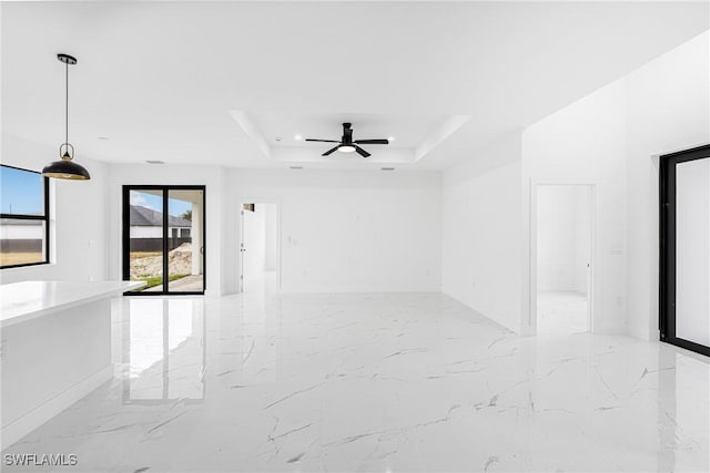 unfurnished room featuring ceiling fan and a tray ceiling