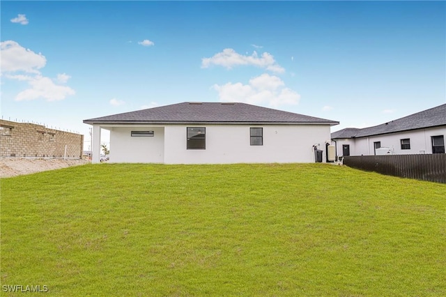 rear view of property featuring a yard