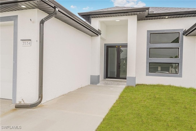 doorway to property with a lawn and french doors