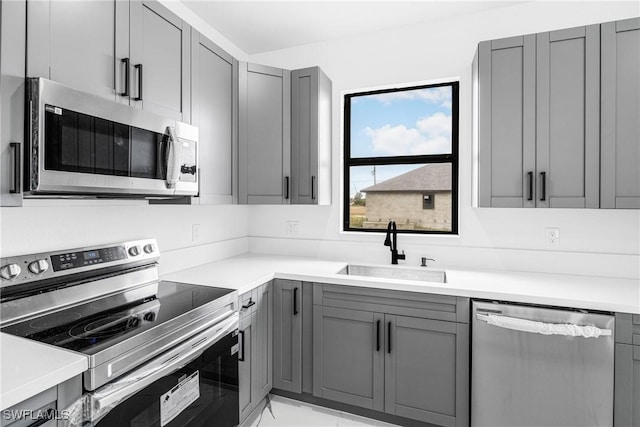 kitchen with sink, gray cabinets, and stainless steel appliances