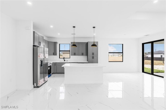 kitchen featuring sink, gray cabinetry, a center island, pendant lighting, and stainless steel appliances