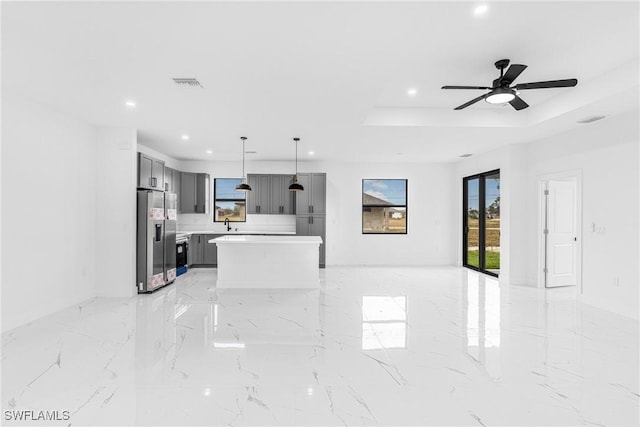 living room with sink, a tray ceiling, and ceiling fan