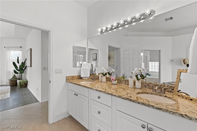 full bathroom with tile patterned flooring, double vanity, visible vents, and a sink